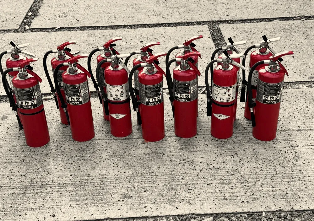 A line of serviced fire extinguishers on the Hamilton Fire Protection bench in Houston